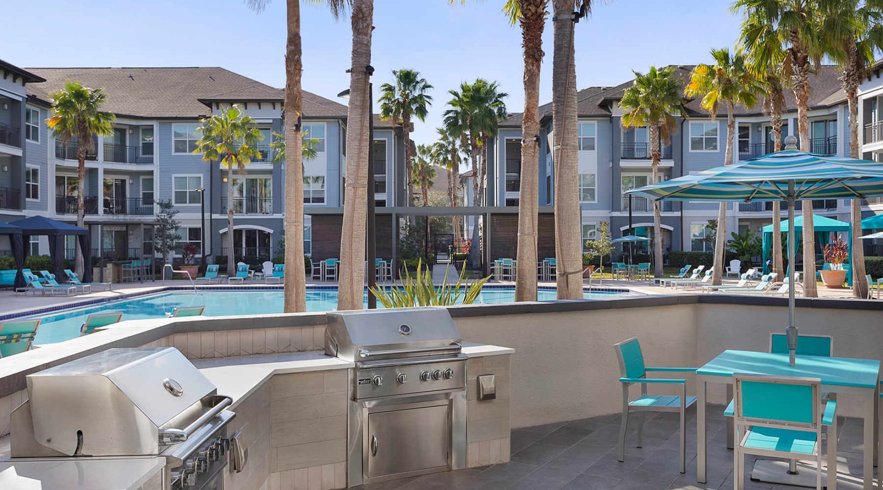 Everything within reach grilling pad, tables and umbrella shaded chairs near pool